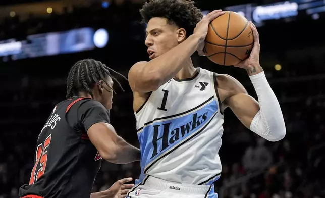 Atlanta Hawks forward Jalen Johnson (1) grabs a rebound against Chicago Bulls forward Julian Phillips (15) during the first half of an NBA basketball game, Thursday, Dec. 26, 2024, in Atlanta. (AP Photo/Mike Stewart)