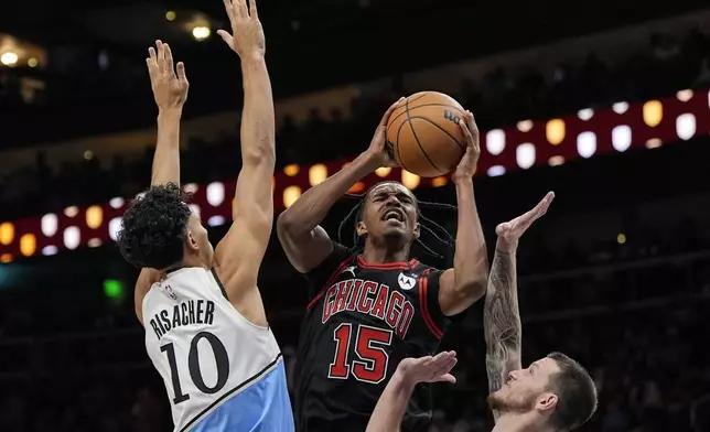 Chicago Bulls forward Julian Phillips (15) shoots against Atlanta Hawks forward Zaccharie Risacher (10) during the first half of an NBA basketball game, Thursday, Dec. 26, 2024, in Atlanta. (AP Photo/Mike Stewart)