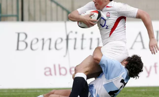 FILE - England's Tom Voyce completes a try despite a tackle from Argentina's Luccio Lopez Fleming during Churchill Cup Final rugby action in Edmonton, June 26, 2005. (John Ulan/The Canadian Press via AP, file)