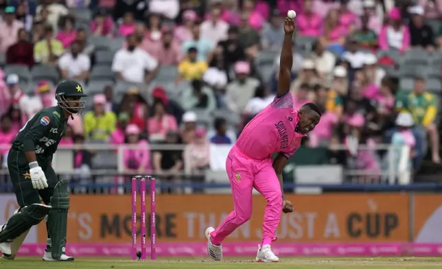 South Africa's Kagiso Rabada, right, bowls as Pakistan's Saim Ayub watches on during the third International cricket match between South Africa and Pakistan, at the Wanderers stadium in Johannesburg, South Africa, Sunday, Dec. 22, 2024. (AP Photo/Themba Hadebe)