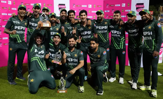 Pakistan's players pose with the trophy following the third International cricket match between South Africa and Pakistan, at the Wanderers stadium in Johannesburg, South Africa, Sunday, Dec. 22, 2024. (AP Photo/Themba Hadebe)