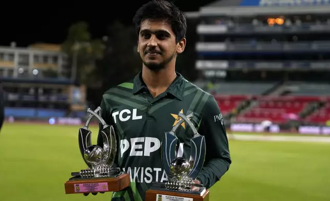 Pakistan's Saim Ayub holds the Player of the Match and Player of the Series trophies following the third International cricket match between South Africa and Pakistan, at the Wanderers stadium in Johannesburg, South Africa, Sunday, Dec. 22, 2024. (AP Photo/Themba Hadebe)