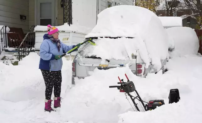 Serena Schodt brushes snow off her car in Erie, Pa., Monday, Dec 2, 2024. AP Photo/Gene J. Puskar)