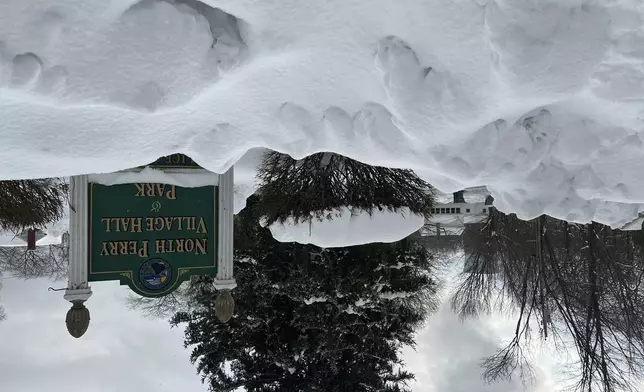 Snow covers the sign for the North Perry Village Hall in North Perry, Ohio on Tuesday, Dec. 3, 2024. (AP Photo/Patrick Aftoora-Orsagos)