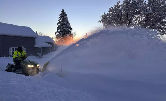 A snowplow clears snow as the sun rises in Lowville, N.Y., Monday, Dec. 2, 2024. (AP Photo/Cara Anna)