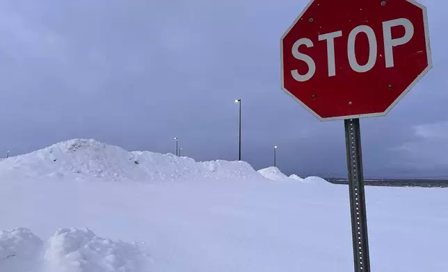 Snow is piled at a parking lot in Lowville, N.Y., Tuesday, Dec. 3, 2024. (AP Photo/Cara Anna)