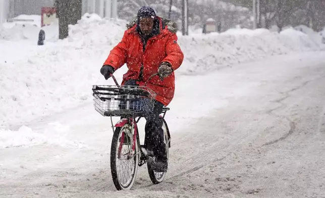 Terrence Yarbrough of Erie, Pa, rides his bicycle through the streets of downtown Erie, Pa, Monday, Dec. 2, 2024. (AP Photo/Gene J. Puskar)