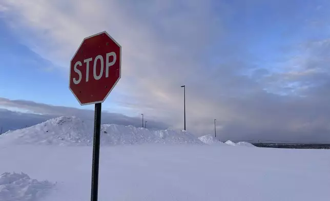 Snow is piled at a parking lot in Lowville, N.Y., on Tuesday, Dec. 3, 2024. (AP Photo/Cara Anna)