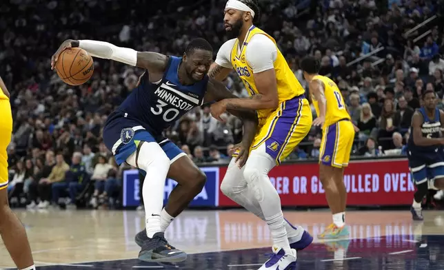 Minnesota Timberwolves forward Julius Randle (30) works toward the basket as Los Angeles Lakers forward Anthony Davis (3) defends during the first half of an NBA basketball game, Friday, Dec. 13, 2024, in Minneapolis. (AP Photo/Abbie Parr)