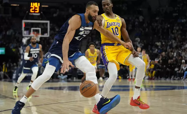 Minnesota Timberwolves center Rudy Gobert (27) works toward the basket as Los Angeles Lakers center Christian Koloko (10) defends during the first half of an NBA basketball game, Friday, Dec. 13, 2024, in Minneapolis. (AP Photo/Abbie Parr)