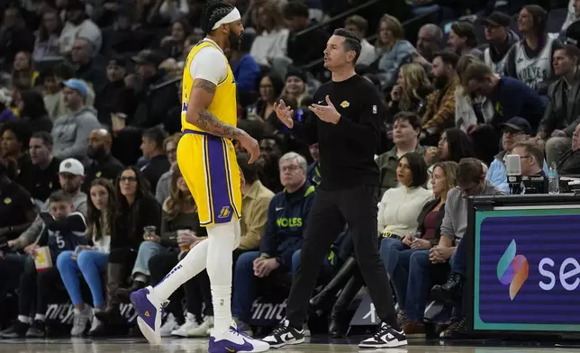 Los Angeles Lakers head coach JJ Redick, right, talks with forward Anthony Davis (3) during the first half of an NBA basketball game against the Minnesota Timberwolves, Friday, Dec. 13, 2024, in Minneapolis. (AP Photo/Abbie Parr)