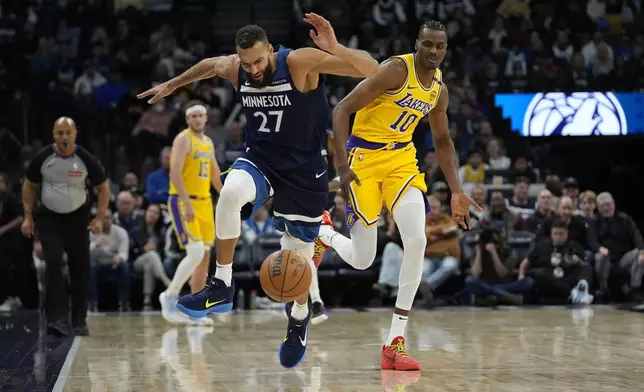 Minnesota Timberwolves center Rudy Gobert (27) and Los Angeles Lakers center Christian Koloko (10) run to gain possession of the ball during the first half of an NBA basketball game, Friday, Dec. 13, 2024, in Minneapolis. (AP Photo/Abbie Parr)