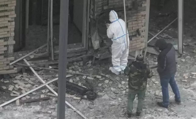 Investigators work near a scooter at the place where Lt. General Igor Kirillov, the head of Russia's Nuclear, Biological, and Chemical Defence Forces and his assistant Ilya Polikarpov were killed by an explosive device planted close to a residential apartment's block in Moscow, Russia, Tuesday, Dec. 17, 2024. (AP Photo)