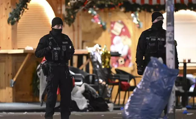 Police stand at a Christmas market in Magdeburg, Germany, early Saturday, Dec. 21, 2024, after a driver plowed into a group of people at the market late Friday. (Hendrik Schmidt/dpa via AP)