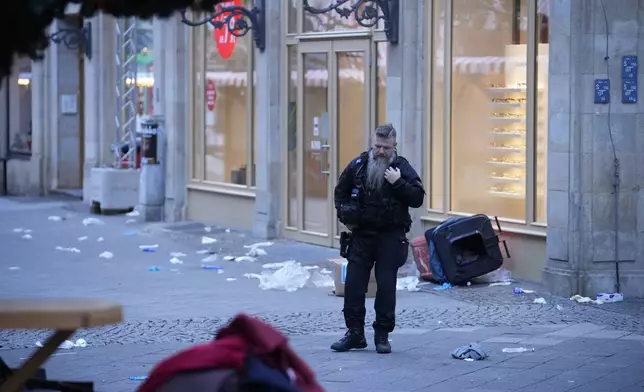 A police officer stands guard at at a cordoned-off area near a Christmas Market, where a car drove into a crowd on Friday evening, in Magdeburg, Germany, Saturday, Dec. 21, 2024. (AP Photo/Ebrahim Noroozi)