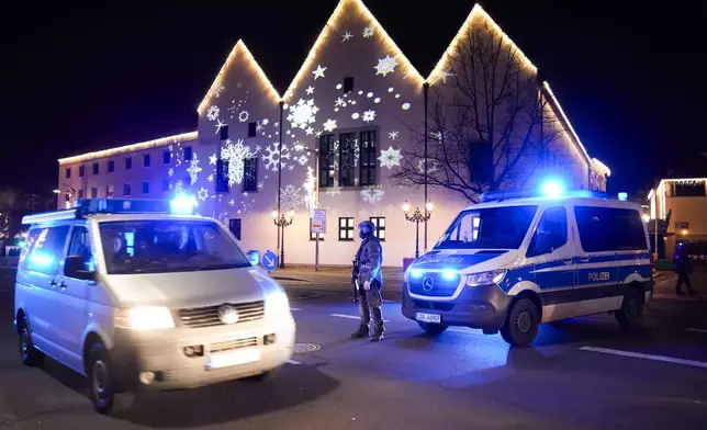 A police officer guards at a blocked road near a Christmas Market, after an incident in Magdeburg, Germany, Friday, Dec. 20, 2024. (AP Photo/Ebrahim Noroozi)