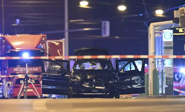 A damaged car sits with its doors open after a driver plowed into a busy Christmas market in Magdeburg, Germany, early Saturday, Dec. 21, 2024. (Hendrik Schmidt/dpa via AP)