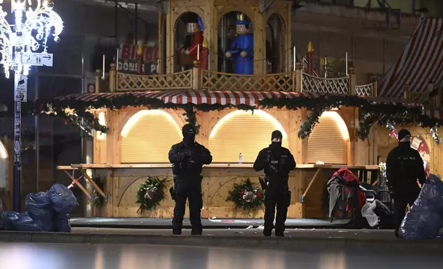 Police stand at a Christmas market in Magdeburg, Germany, early Saturday, Dec. 21, 2024, after a driver plowed into a group of people at the market late Friday. (Hendrik Schmidt/dpa via AP)