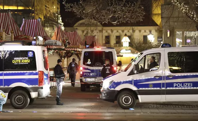 Police officers and police emergency vehicles are seen at the Christmas market in Magdeburg after a driver plowed into a busy Christmas market in Magdeburg, Germany, Saturday, Dec. 21, 2024. (Matthias Bein/dpa via AP)