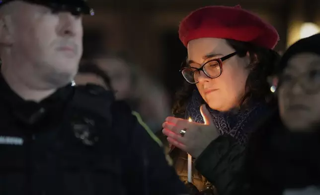 A supporter holds a candle during a candlelight vigil Tuesday, Dec. 17, 2024, outside the Wisconsin Capitol in Madison, Wis., following a shooting at the Abundant Life Christian School on Monday, Dec. 16. (AP Photo/Morry Gash)