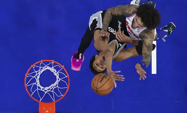 Philadelphia 76ers' Kelly Oubre Jr., right, goes up for a shot against San Antonio Spurs' Victor Wembanyama during the second half of an NBA basketball game, Monday, Dec. 23, 2024, in Philadelphia. (AP Photo/Matt Slocum)