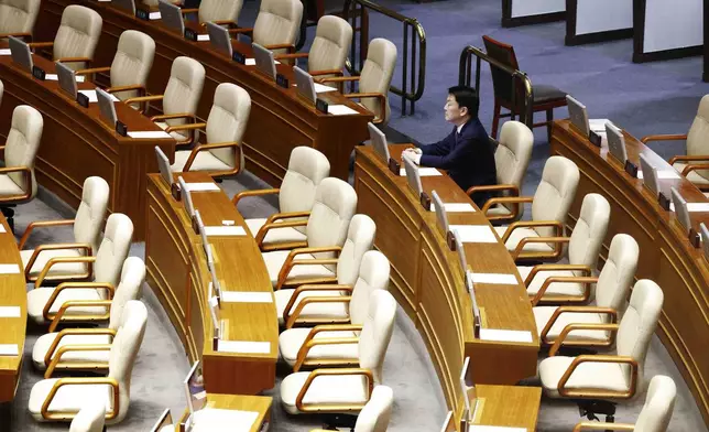 Lawmaker Ahn Chul-soo sits alone, the only People Power Party lawmaker who remains in the voting chamber during the plenary session for the impeachment vote of South Korean President Yoon Suk Yeol is set to take place at the National Assembly in Seoul, South Korea, Saturday, Dec. 7, 2024. (Jeon Heon-kyun/Pool Photo via AP)