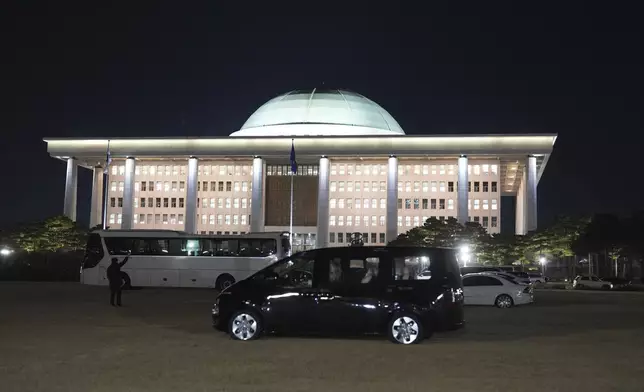Vehicles are parked on the lawn of the National Assembly to prevent helicopters from landing due to concerns of any possible additional acts following the President's short-lived martial law declaration at the National Assembly in Seoul, South Korea, Friday, Dec. 6, 2024. (AP Photo/Lee Jin-man)