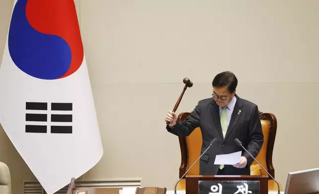 South Korean National Assembly Speaker Woo Won-shik announces bangs the gavel to announce that "the voting cannot take place" because the quorum was not reached during a plenary session for the impeachment vote of South Korean President Yoon Suk Yeol is set to take place at the National Assembly in Seoul, South Korea, Saturday, Dec. 7, 2024. (Jeon Heon-kyun/Pool Photo via AP)