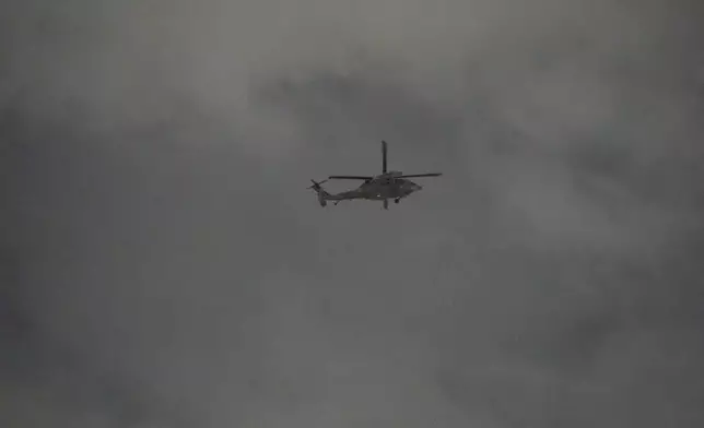 A helicopter flies over the National Assembly in Seoul, South Korea, Wednesday, Dec. 4, 2024. (AP Photo/Lee Jin-man)