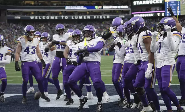 Minnesota Vikings linebacker Dallas Turner (15), center, celebrates with teammates after intercepting a pass during the first half of an NFL football game against the Seattle Seahawks, Sunday, Dec. 22, 2024, in Seattle. (AP Photo/Lindsey Wasson)