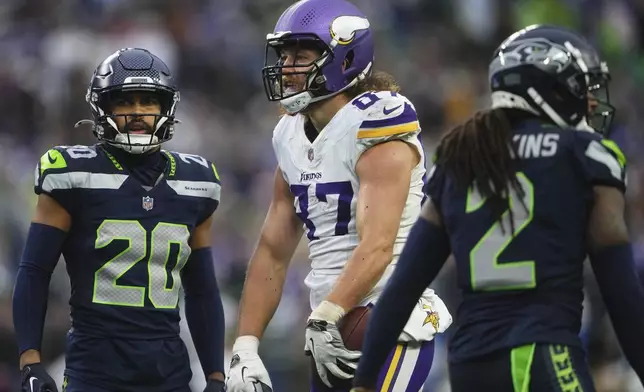 Minnesota Vikings tight end T.J. Hockenson (87) celebrates after catching a pass against Seattle Seahawks safeties Julian Love (20) Rayshawn Jenkins (2) during the second half of an NFL football game, Sunday, Dec. 22, 2024, in Seattle. (AP Photo/Lindsey Wasson)