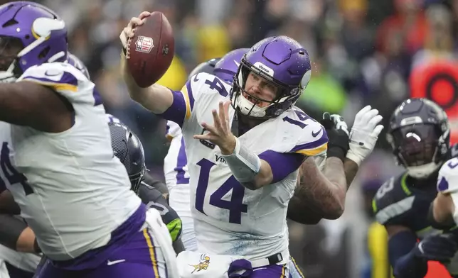 Minnesota Vikings quarterback Sam Darnold (14) is sacked by Seattle Seahawks defensive tackle Jarran Reed (90) during the first half of an NFL football game, Sunday, Dec. 22, 2024, in Seattle. (AP Photo/Lindsey Wasson)