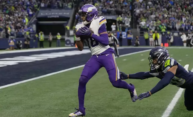 Minnesota Vikings wide receiver Justin Jefferson (18) scores a 39-yard touchdown ahead of Seattle Seahawks safety Julian Love (20) during the second half of an NFL football game, Sunday, Dec. 22, 2024, in Seattle. (AP Photo/Stephen Brashear)