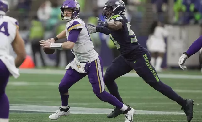 Minnesota Vikings quarterback Sam Darnold (14) is sacked by Seattle Seahawks linebacker Boye Mafe (53) during the first half of an NFL football game, Sunday, Dec. 22, 2024, in Seattle. (AP Photo/Stephen Brashear)