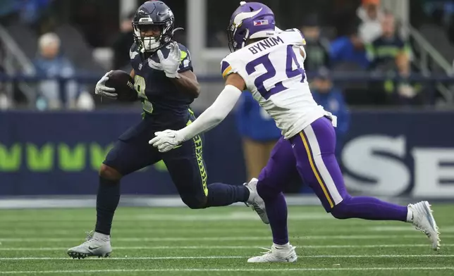 Seattle Seahawks running back Kenneth Walker III (9) runs with the football as Minnesota Vikings safety Camryn Bynum (24) tries to tackle during the second half of an NFL football game, Sunday, Dec. 22, 2024, in Seattle. (AP Photo/Lindsey Wasson)