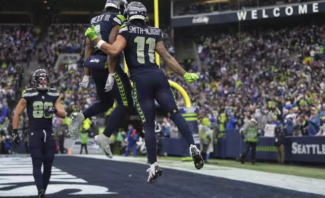 Seattle Seahawks wide receiver Jaxon Smith-Njigba (11) celebrates after scoring an 18-yard touchdown during the first half of an NFL football game against the Minnesota Vikings, Sunday, Dec. 22, 2024, in Seattle. (AP Photo/Lindsey Wasson)