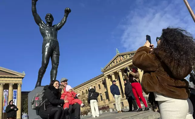 Visitors gather around the Rocky Statue and the “Rocky Steps” during RockyFest 2024 at the Philadelphia Museum of Art, Tuesday, Dec. 3, 2024, in Philadelphia. (AP Photo Tassanee Vejpongsa)