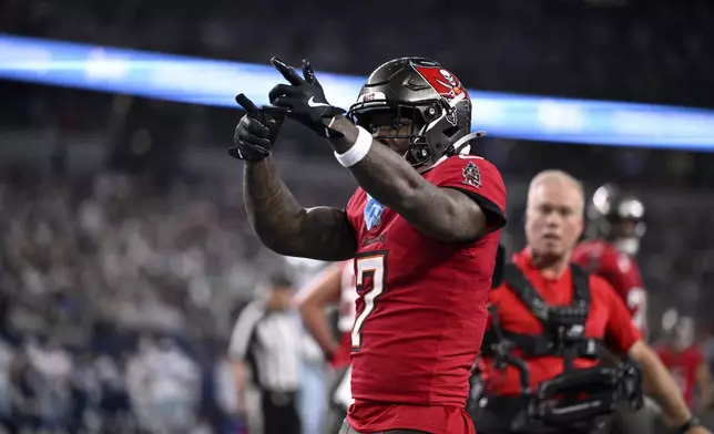 Tampa Bay Buccaneers running back Bucky Irving celebrates after rushing for a touchdown against th eDallas Cowboys in the first half of an NFL football game in Arlington, Texas, Sunday, Dec. 22, 2024. (AP Photo/Jerome Miron)