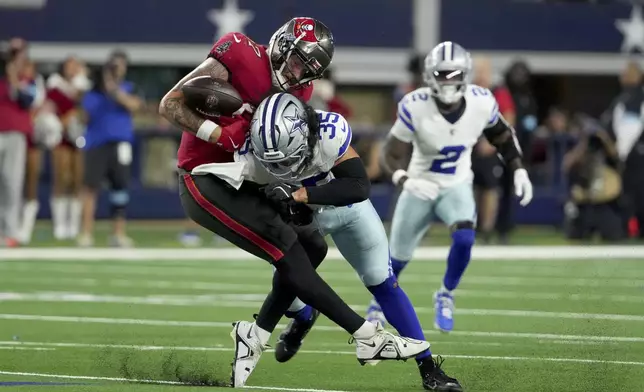 Tampa Bay Buccaneers tight end Payne Durham (87) is uanble to secure a pass as Dallas Cowboys linebacker Marist Liufau (35) delivers a hard hit in the second half of an NFL football game in Arlington, Texas, Sunday, Dec. 22, 2024. (AP Photo/Jeffrey McWhorter)