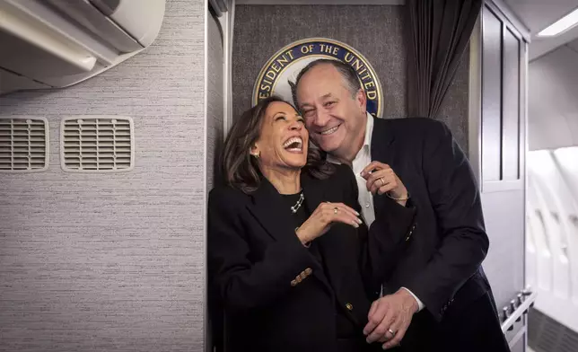 Democratic presidential nominee Vice President Kamala Harris, left, shares a laugh with second gentleman Doug Emhoff, after reuniting in Pittsburgh, Monday, Nov. 4, 2024, aboard Air Force Two, just before taking off from Pittsburgh for her final campaign rally in Philadelphia. (AP Photo/Jacquelyn Martin, Pool)