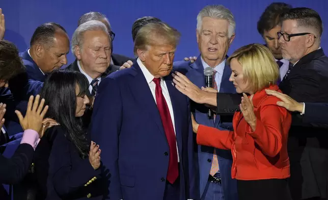 Republican presidential nominee former President Donald Trump is prayed over with Pastor Paula White during the National Faith Summit at Worship With Wonders Church, Monday, Oct. 28, 2024, in Powder Springs, Ga. (AP Photo/Brynn Anderson)