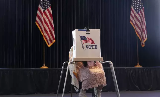 A voter works on her ballot at a polling place at the Ronald Reagan Presidential Library on Election Day, Tuesday, Nov. 5, 2024, in Simi Valley, Calif. (AP Photo/Chris Pizzello)