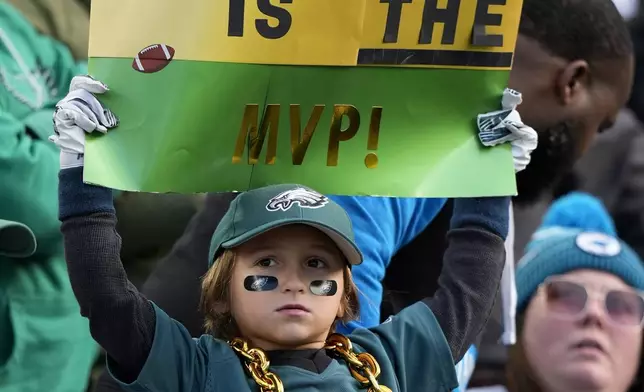 A fan holds a sign for Philadelphia Eagles running back Saquon Barkley (26) during the second half of an NFL football game between the Eagles and the Carolina PanthersSunday, Dec. 8, 2024, in Philadelphia. (AP Photo/Chris Szagola)