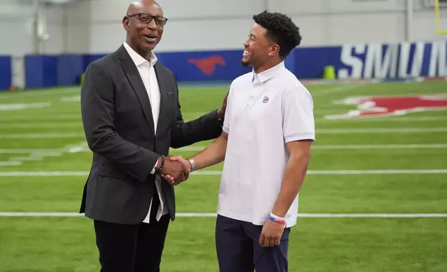 Former NFL and SMU running back Eric Dickerson left, chats with SMU safety Jonathan McGill after a panel discussion about NIL and NCAA college football, Tuesday, Dec. 3, 2024, in Dallas. (AP Photo/LM Otero)