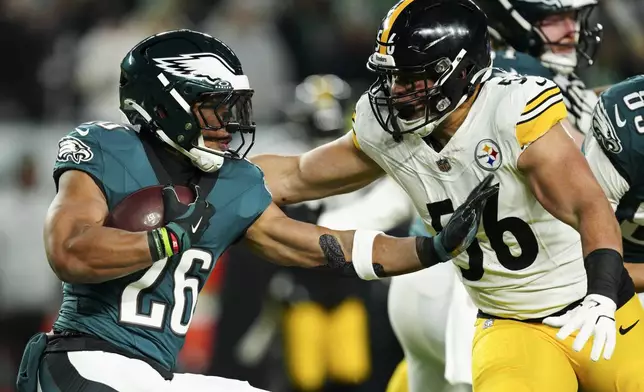 Philadelphia Eagles running back Saquon Barkley (26) is tackled by Pittsburgh Steelers linebacker Alex Highsmith (56) during the first half of an NFL football game Sunday, Dec. 15, 2024, in Philadelphia. (AP Photo/Derik Hamilton)