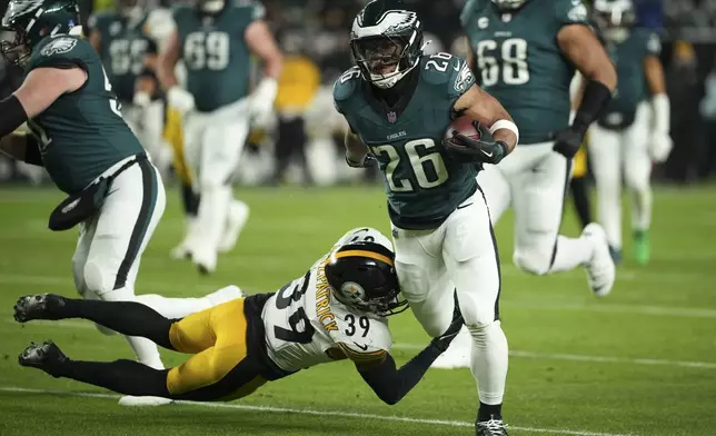 Philadelphia Eagles running back Saquon Barkley (26) runs with the ball as Pittsburgh Steelers safety Minkah Fitzpatrick (39) tries to stop him during the first half of an NFL football game Sunday, Dec. 15, 2024, in Philadelphia. (AP Photo/Matt Slocum)