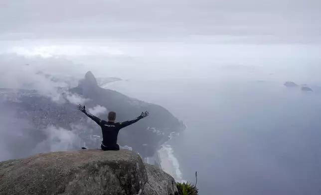 Ezequiel da Luz, a para-athlete with an amputated leg and no movement in his lower limbs, celebrates reaching the top of Pedra da Gavea, with an organization that aims to increase accessibility in trails, in Rio de Janeiro, Wednesday, Dec. 18, 2024. (AP Photo/Lucas Dumphreys)