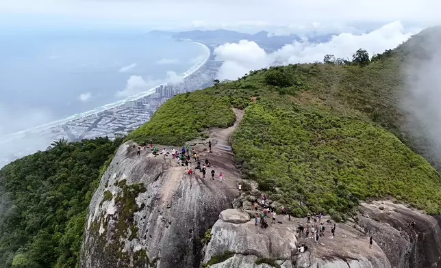 Volunteers reach the top of Pedra da Gavea, during a project to increase accessibility in trails in Rio de Janeiro, Wednesday, Dec. 18, 2024. (AP Photo/Lucas Dumphreys)