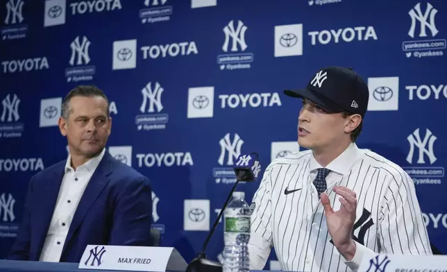 New York Yankees manager Aaron Boone, left, watches as Max Fried speaks during a baseball news conference, Wednesday, Dec. 18, 2024, in New York. (AP Photo/Frank Franklin II)