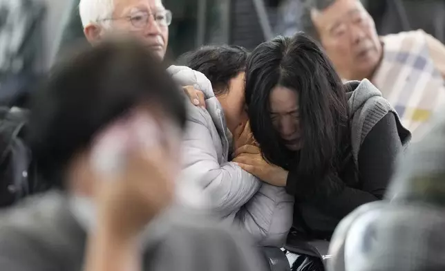 Relatives of passengers on a plane which skidded off a runway and burst into flames, react at Muan International Airport in Muan, South Korea, Monday, Dec. 30, 2024. (AP Photo/Ahn Young-joon)